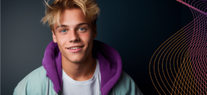 En leende ung man med blont hår, klädd i en ljusblå jacka och en lila hoodie, med ett mörkt mönster och abstrakt linjemönster till höger i bakgrunden.
